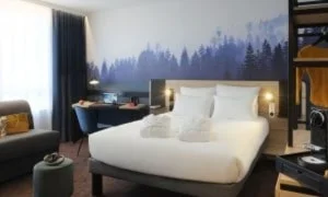 Una habitación de hotel con una cama y un escritorio.