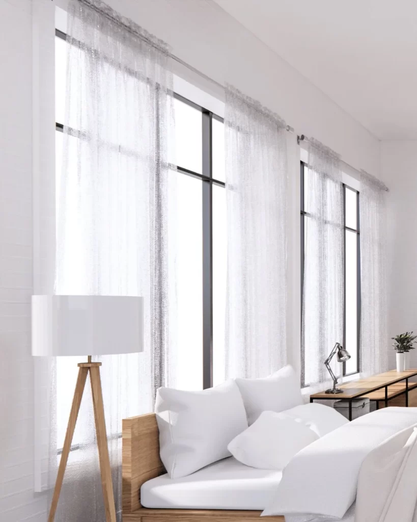 Un dormitorio moderno con paredes blancas y suelos de madera.